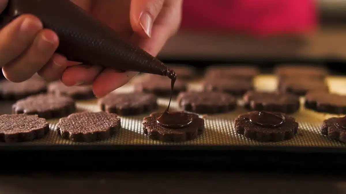 チョコレートサンドに溶かしたチョコレートをしぼっている