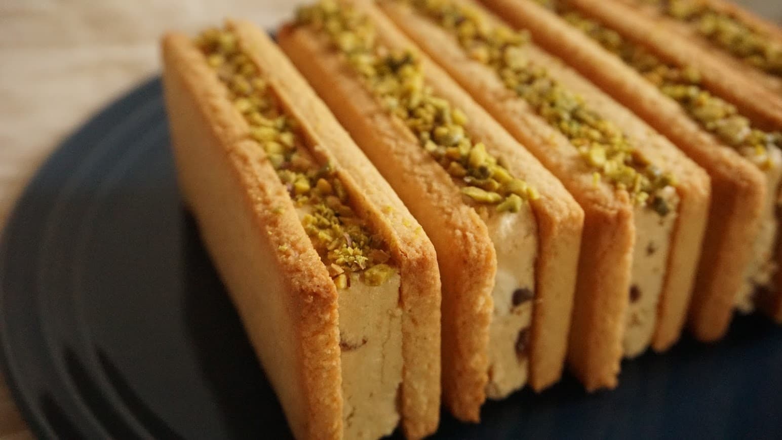 小麦アレルギーでも食べられる、ピスタチオのバターサンドが黒いお皿に並べられている。