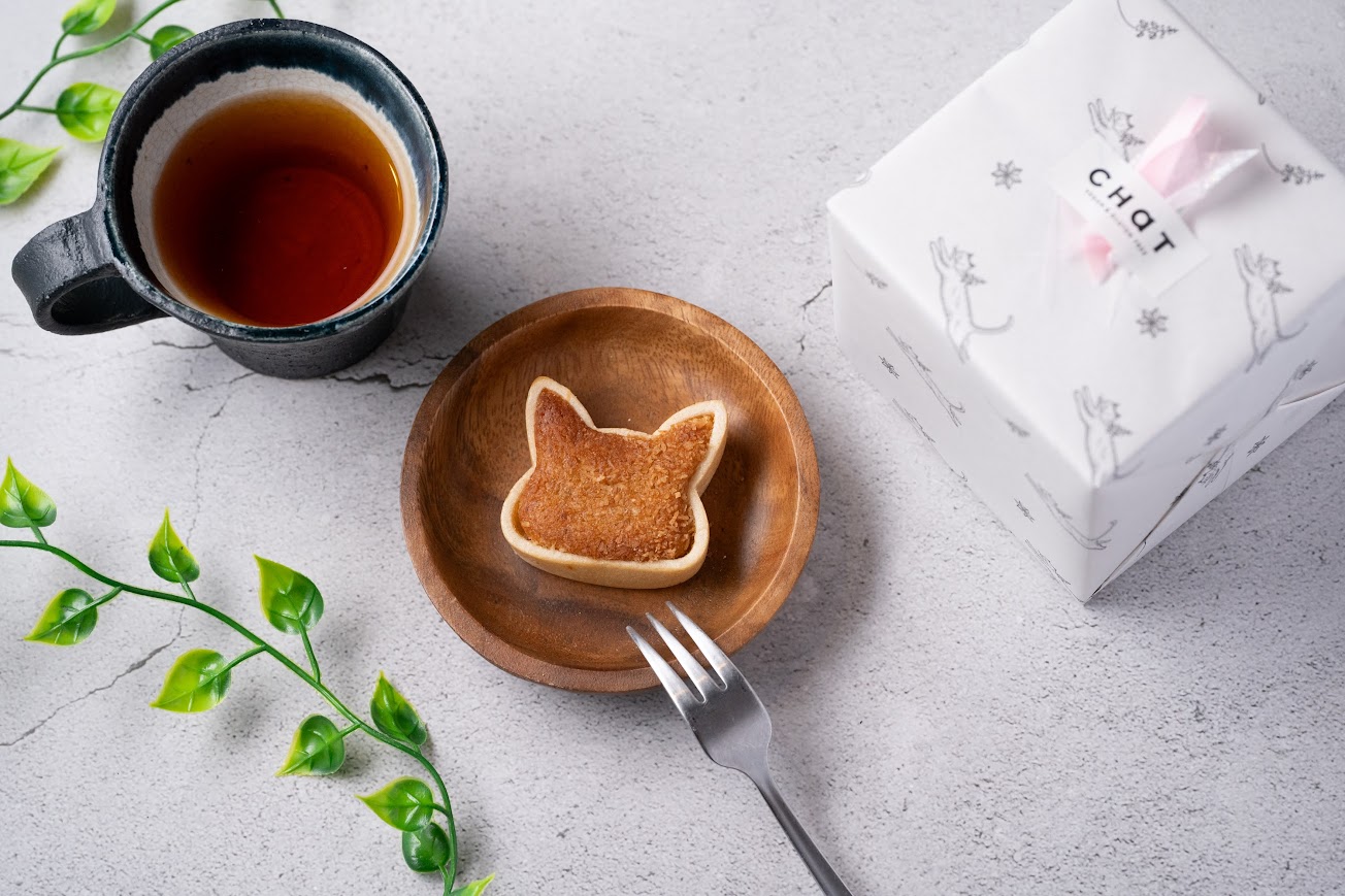 木のお皿に乗った小麦アレルギー対応のお菓子、紅茶が机の上に置いてある。