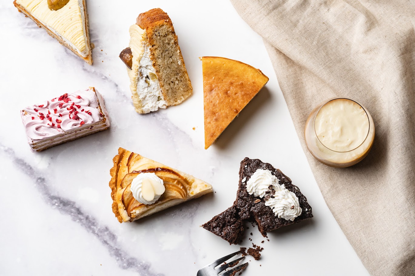 様々なヴィーガンケーキが1ピースずつ大理石に置かれている。