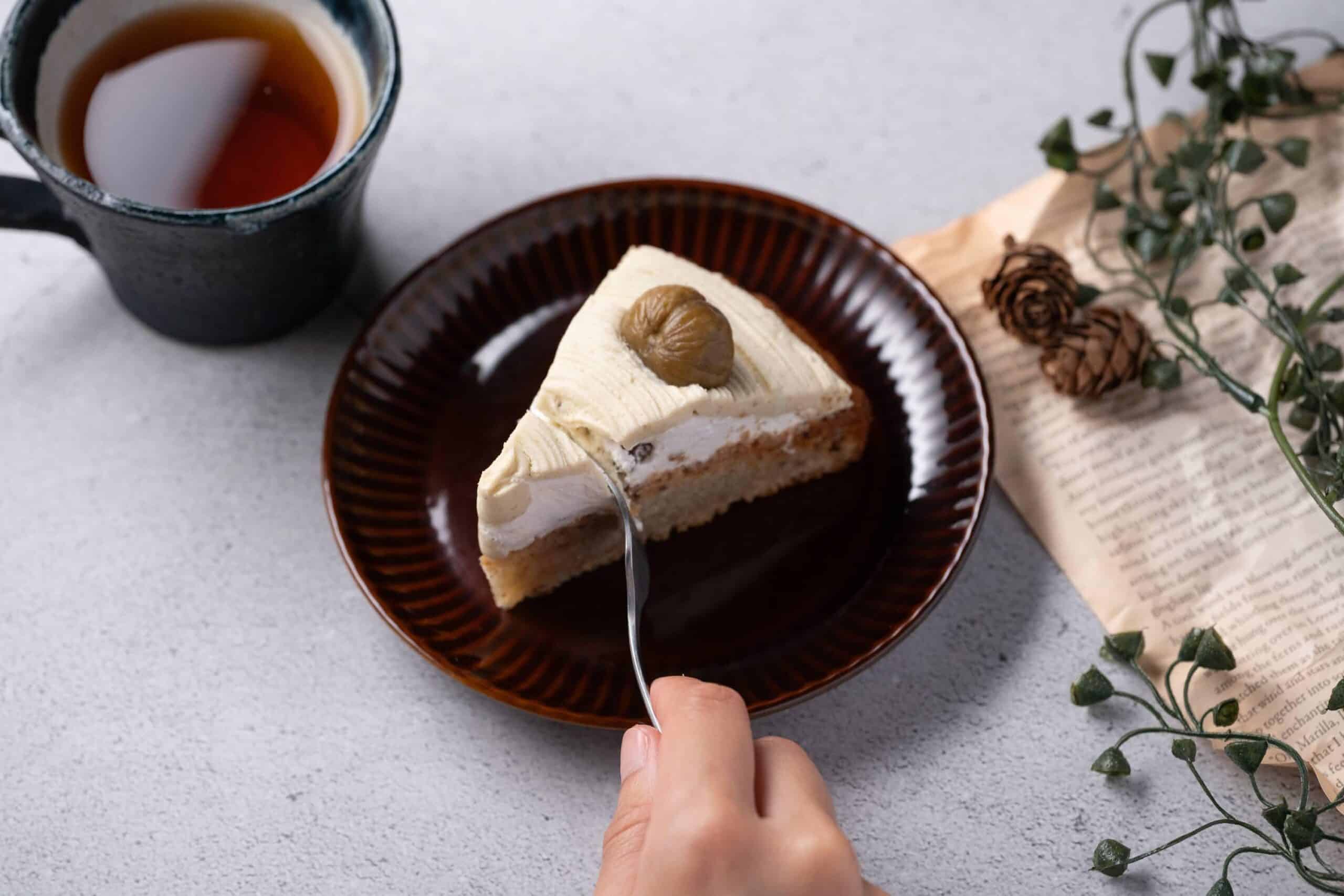 お皿に乗ったモンブランをフォークで切り、紅茶とともに楽しもうとしている様子。